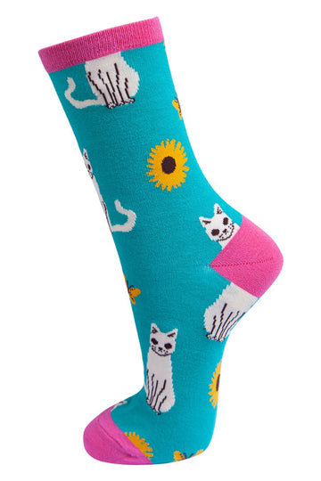 blue and pink bamboo socks with a pattern of white cats and yellow sunflowers