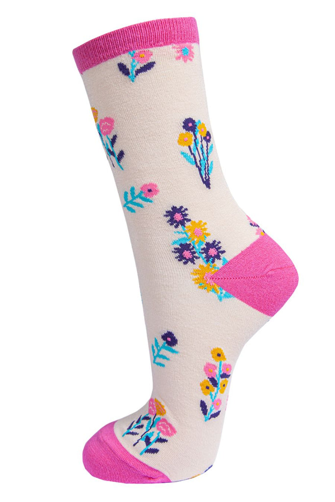 cream socks with a multicoloured ditsy floral pattern and fuchsia pink heel, toe and cuff