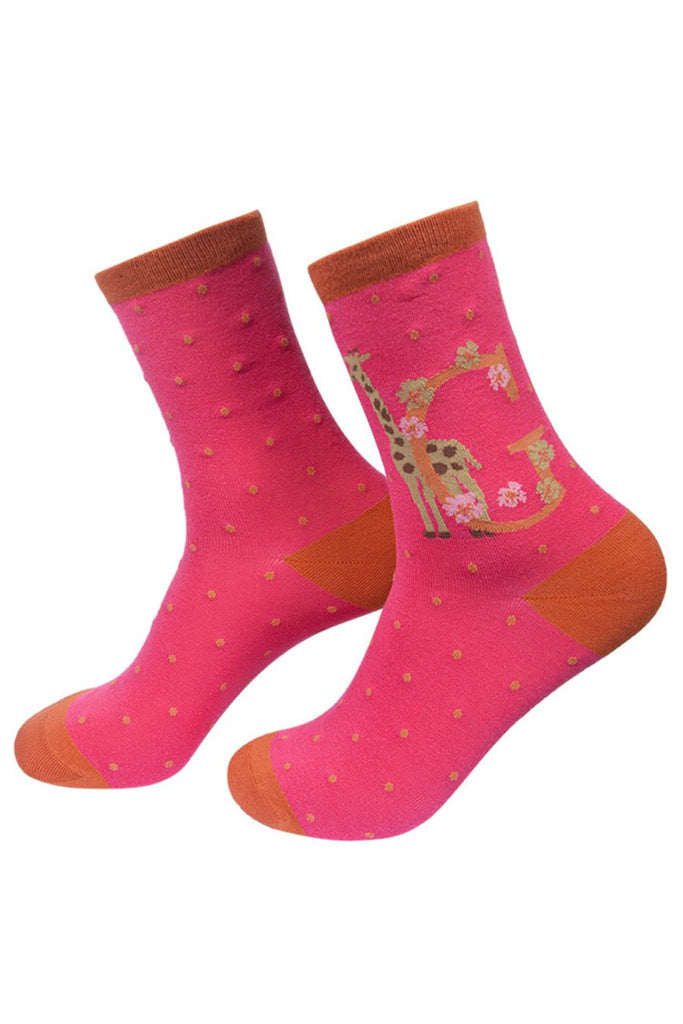 hot pink socks with a large letter g, a giraffe and a floral pattern on the ankle