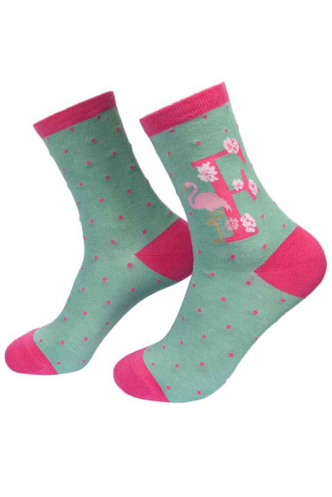 light green socks with a large letter f, a flamingo and a floral pattern on the ankle