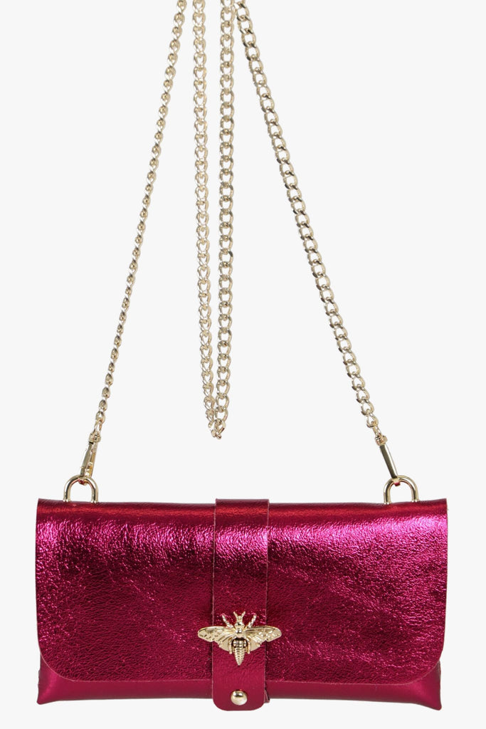 magenta pink leather clutch bag with a detachable crossbody gold chain strap and gold bee clasp on the front