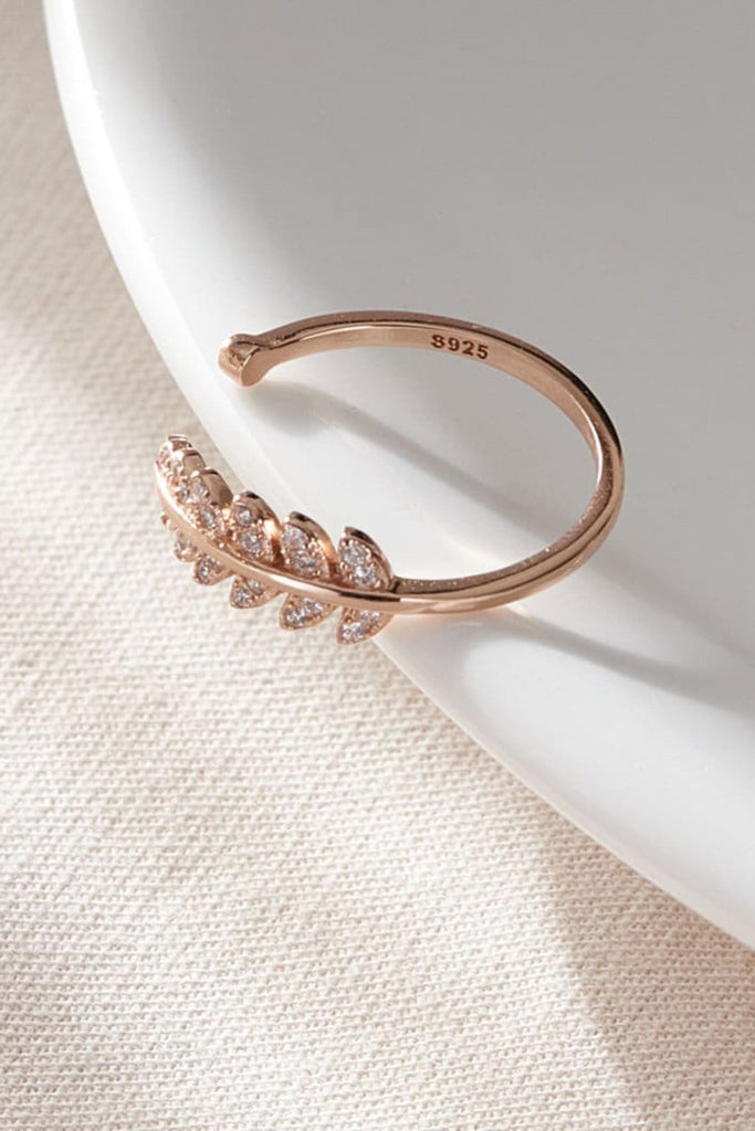laying flat, the rose gold coloured S925 leaf ring, showing the clear cz stones of the lead design