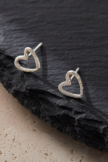 sterling silver heart outline stud earrings with a textured frosted surface