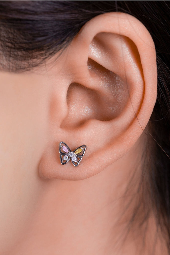 earring being worn on an earlobe, showing the dainty size of the silver studs