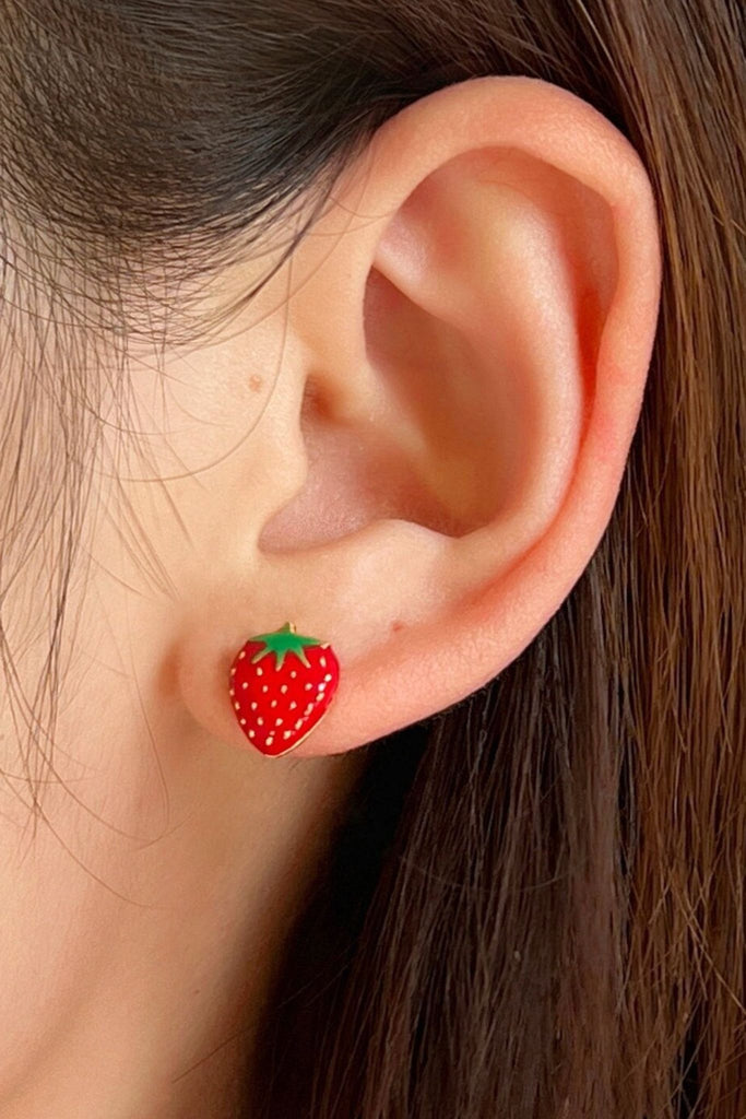sterling silver red strawberry stud earring being worn on the earlobe