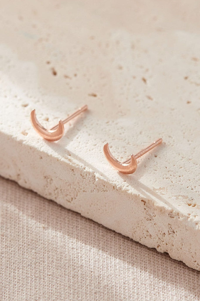 close up of the rose gold crescent moon dainty stud earrrings