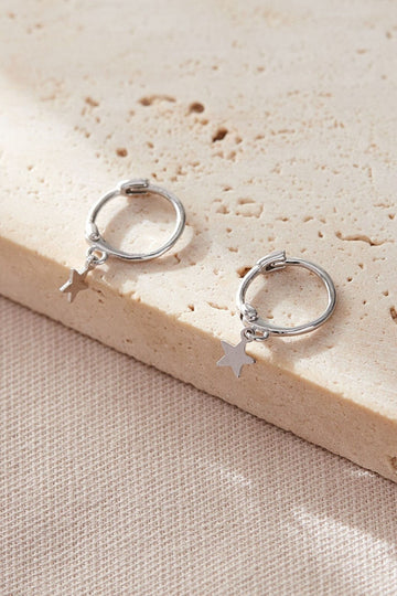 showing the sterling silver star charm earrings, laying flat