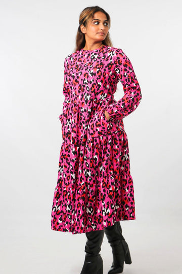 model wearing a pink leopard print midi tiered dress with long sleeves