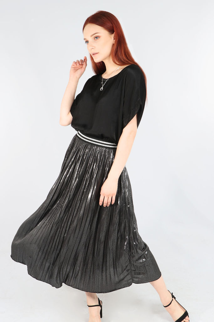 model wearing a pleated black silver metallic foil midi skirt