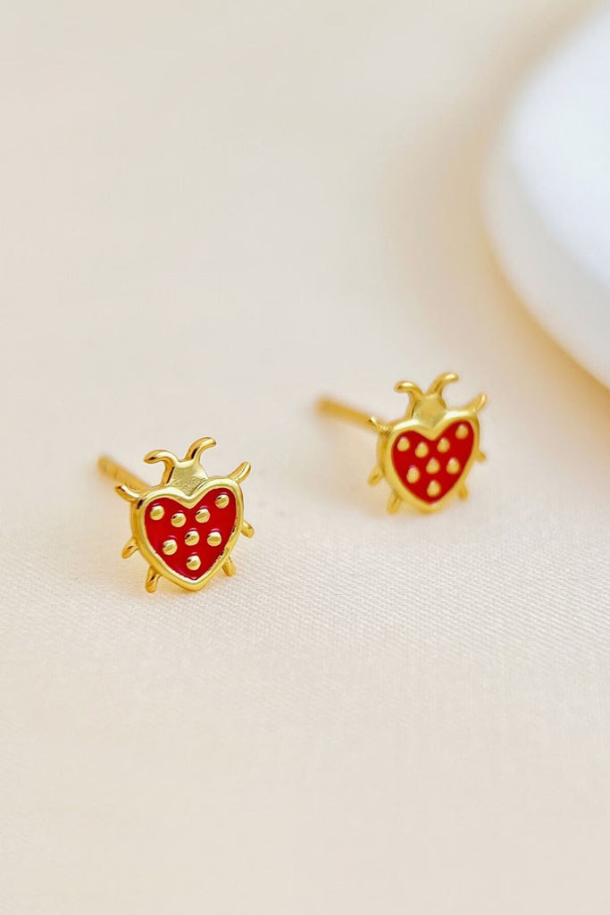 gold and red ladybug stud earrings shaped like a love heart