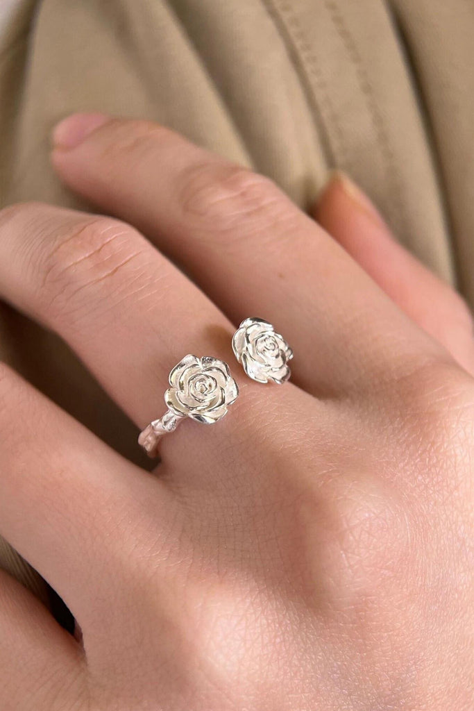 model wearing the ring on a finger, showing that it is open and adjustable