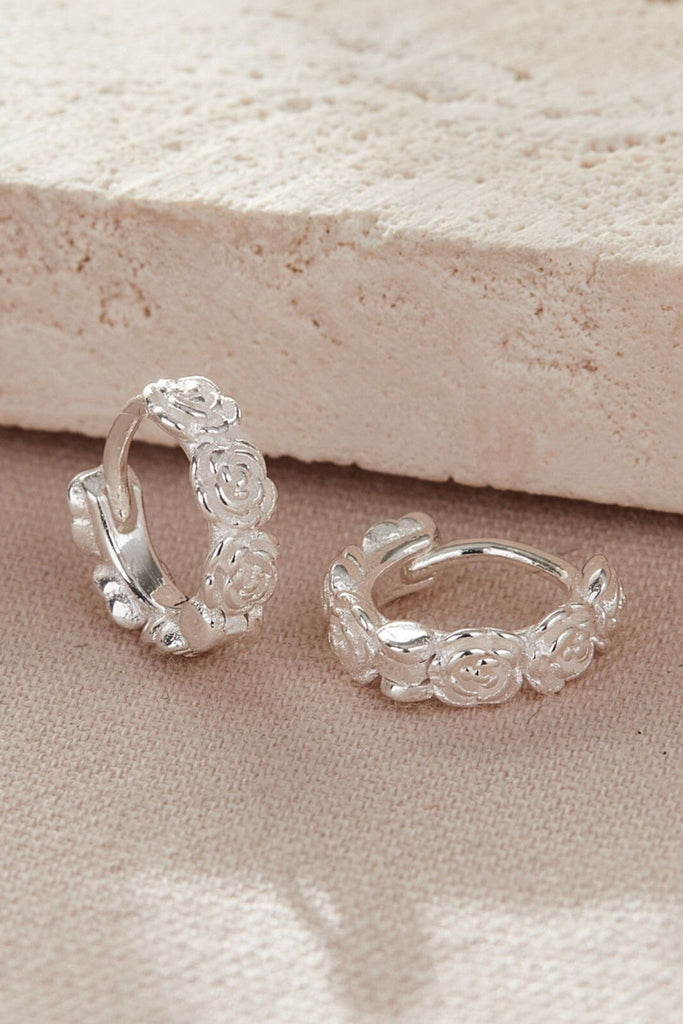 sterling silver huggie hoop earrings designed to look like a wreath of rose flowers