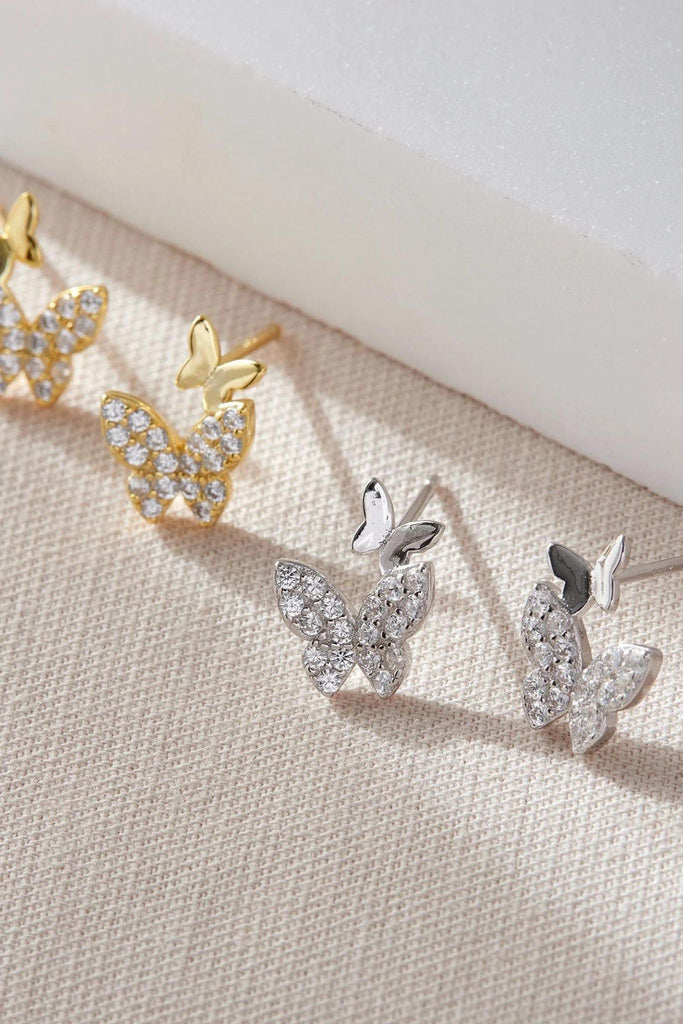 silver and gold coloured S925 and white cubic zirconia sparkly butterfly stud earrings, each stud has two butterflies, one large one with sparkly cz and one small plain one