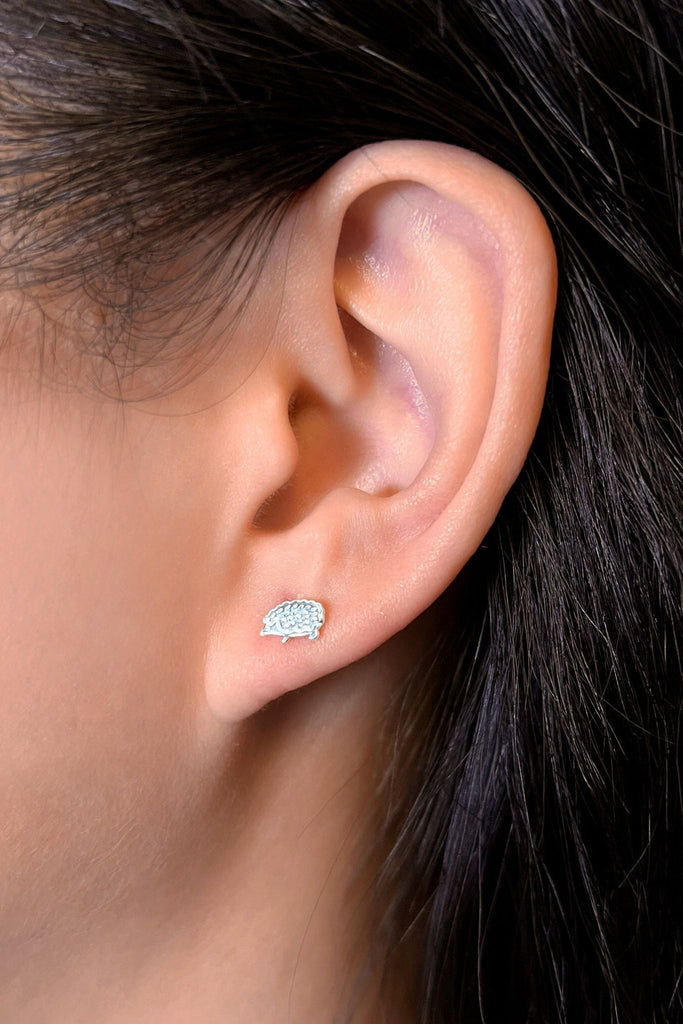 model wearing one of the silver hedgehog studs in the earlobe, showing the dainty size of the studs