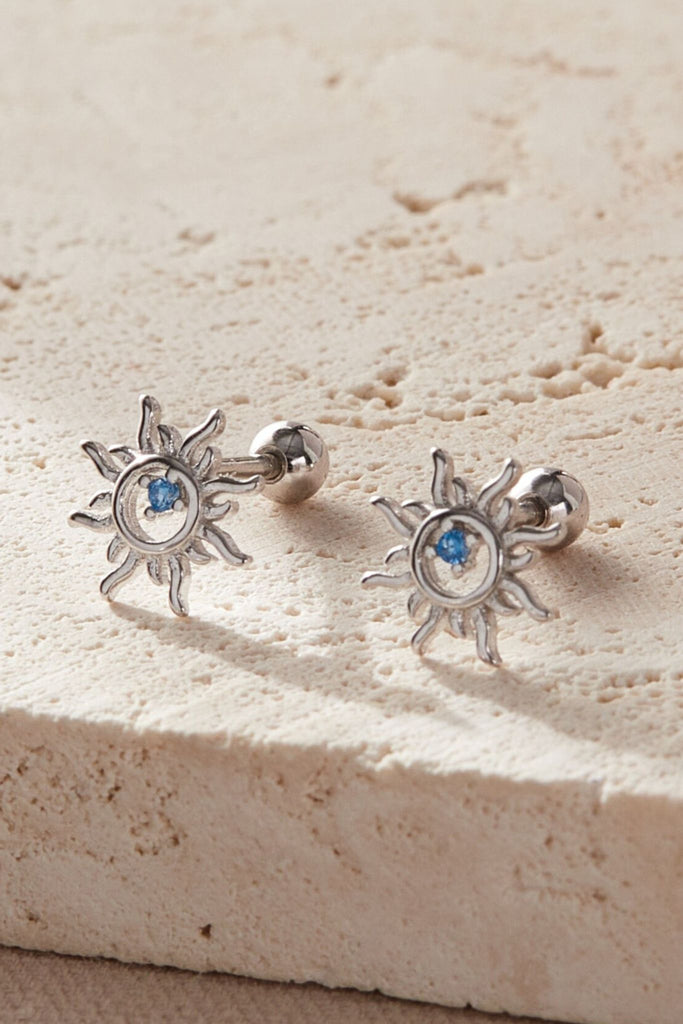 close up of the silver sun cartilage stud earrings, showing the ball back fastenings