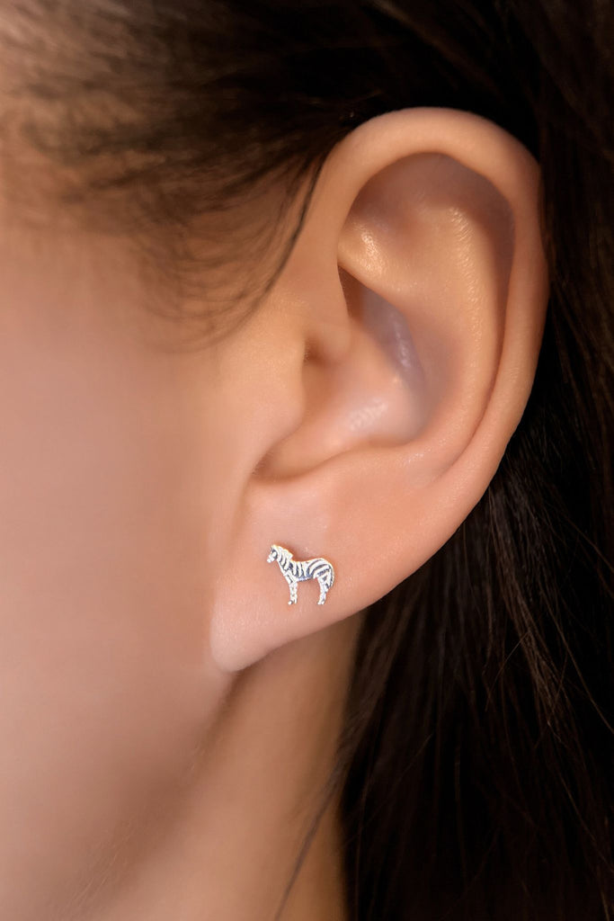 model wearing this silver zebra stud earring in the earlobe, showing the dainty size of the earrings