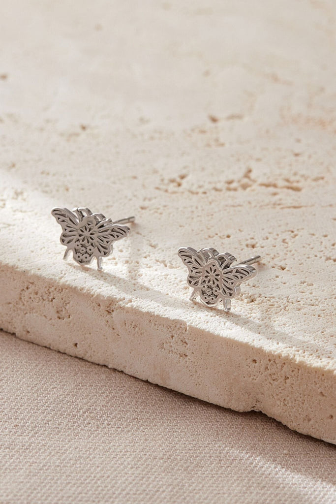 close up of the silver daisy floral pattern on the bee stud earrings