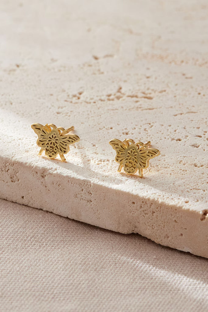 close up of the gold daisy floral pattern on the bee stud earrings