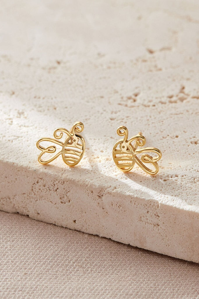 close up of the gold bee stud earrings, showing that the wings are designed like a love heart 