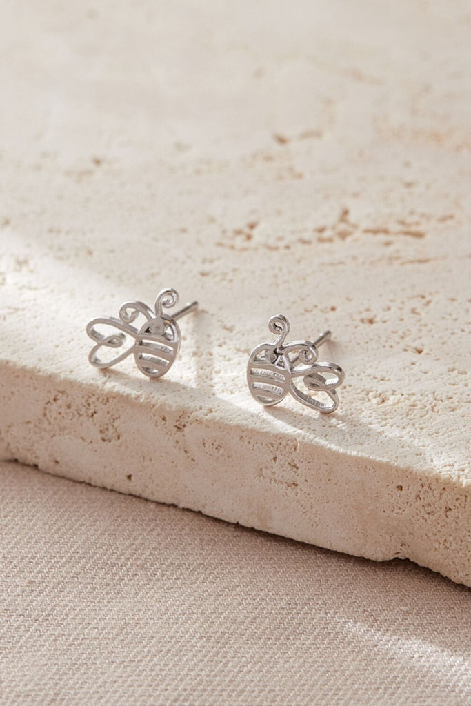 close up of the silver bee stud earrings, showing that the wings are designed like a love heart 