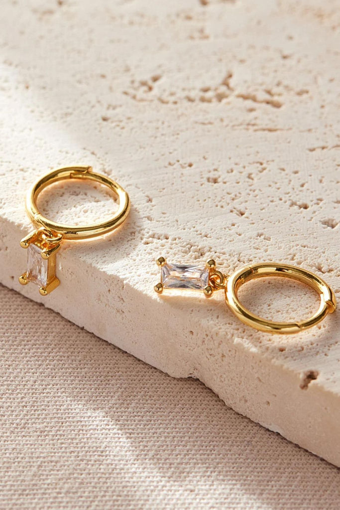 close up of the clear white cz gold dangle hoop earrings