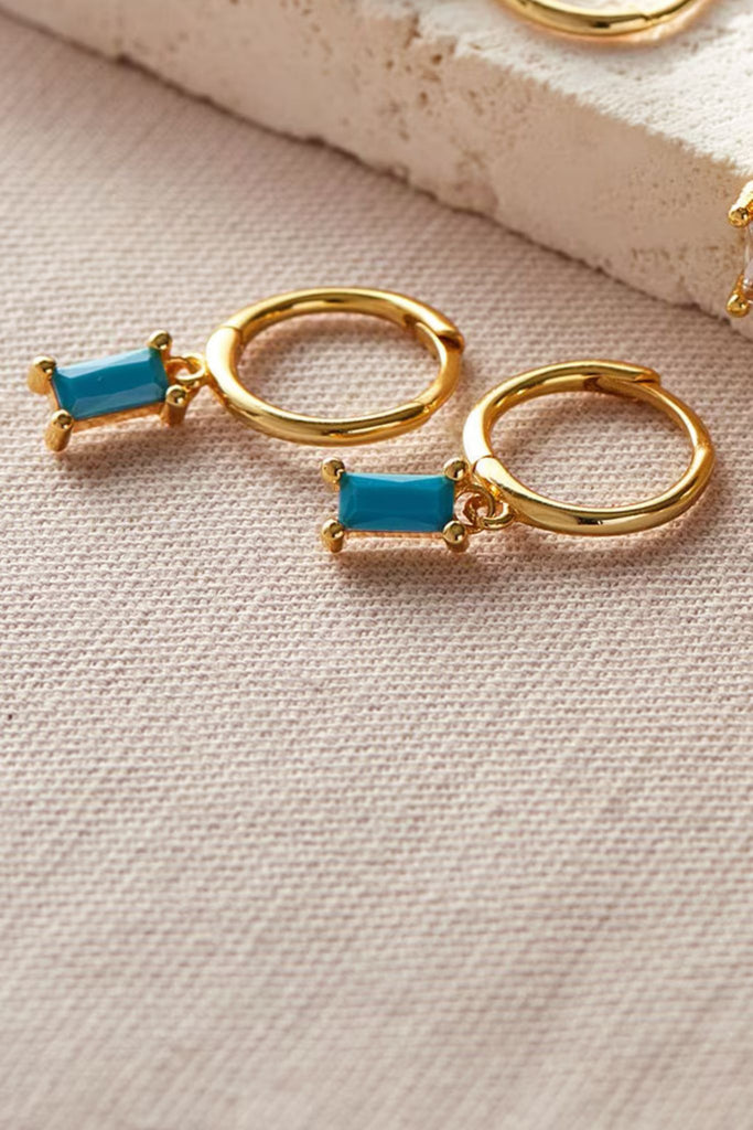 close up of the turquoise blue cz gold dangle hoop earrings