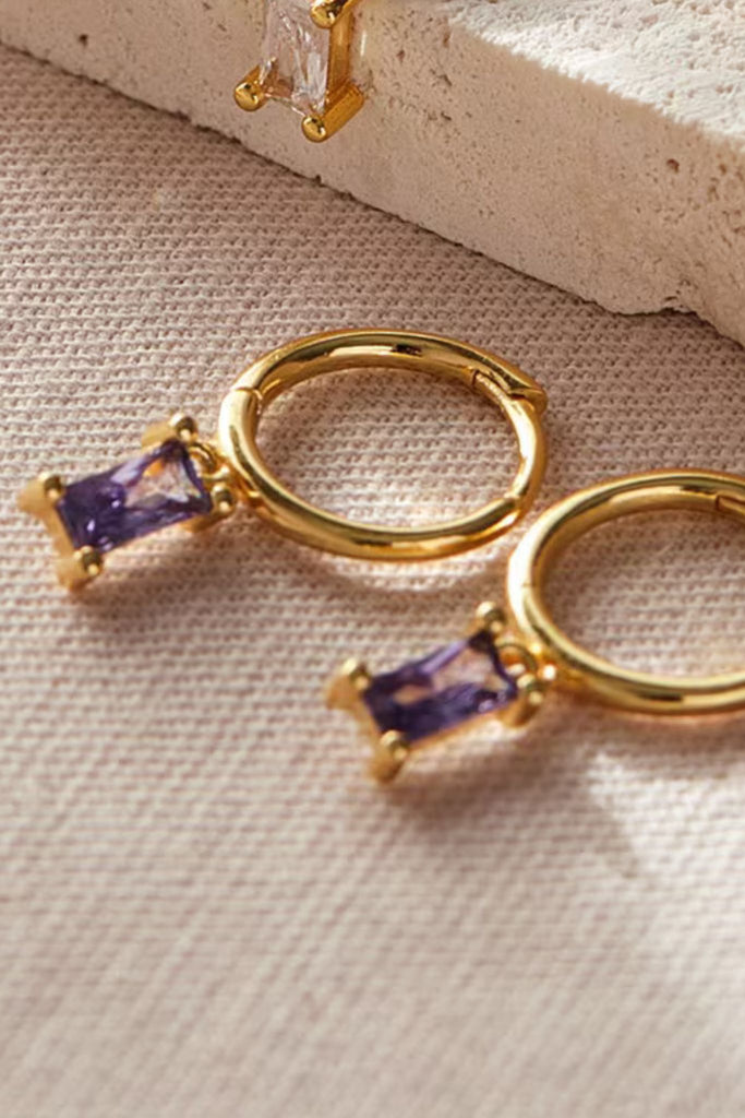 close up of the purple cz gold dangle hoop earrings