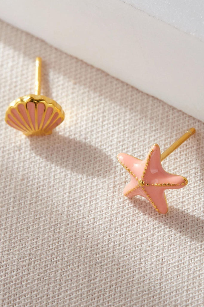 close up of the gold plated sterling silver coral seashell and star fish asymmetrical stud earrings