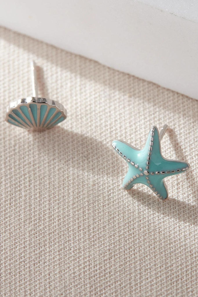 close up of the  sterling silver blue seashell and star fish asymmetrical stud earrings
