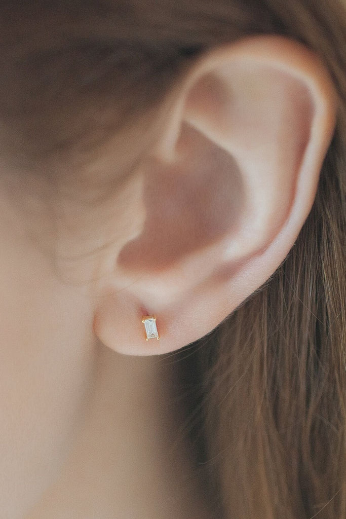 model wearing the white rectangular sparkly stud earring in the earlobe