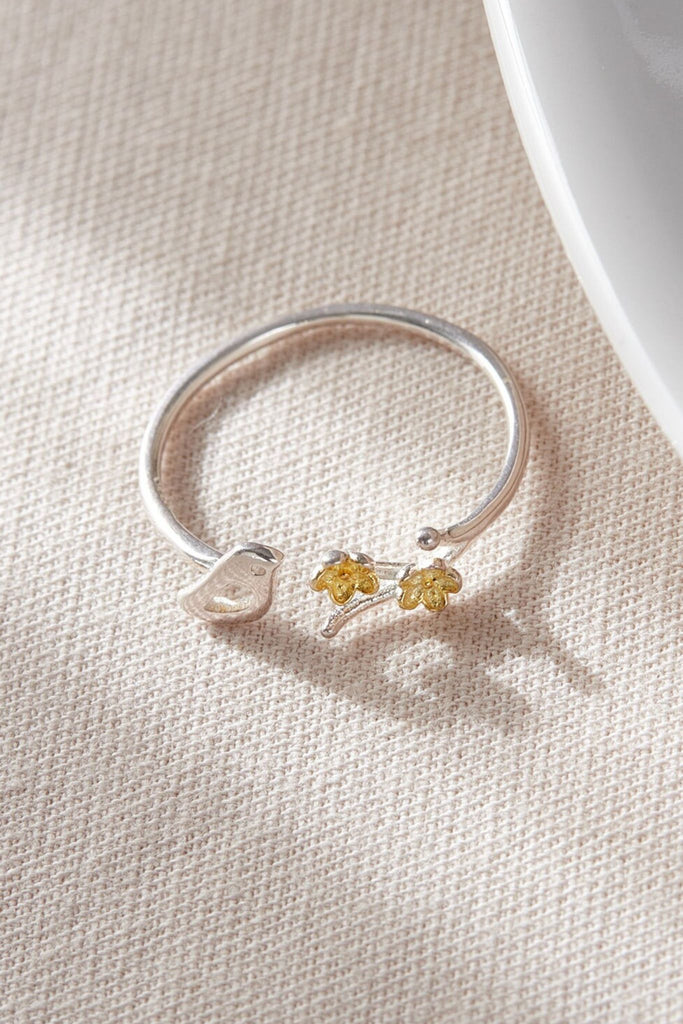 close up of the bird and flower design on the silver ring