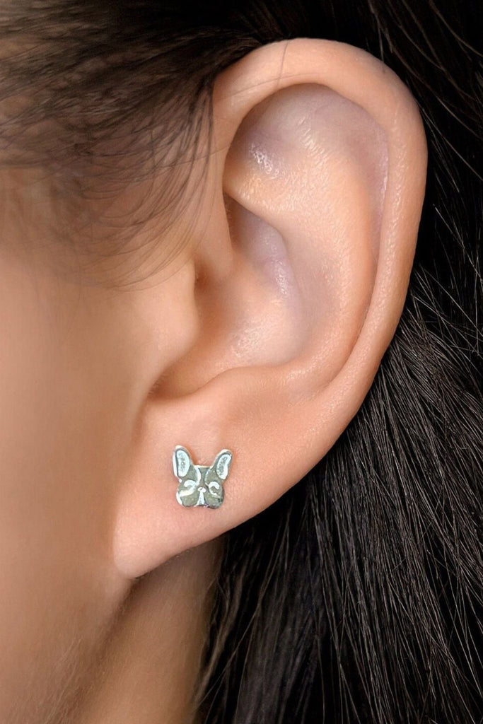 model wearing the silver french bulldog stud earring in the earlobe, showing the dainty size of the earrings