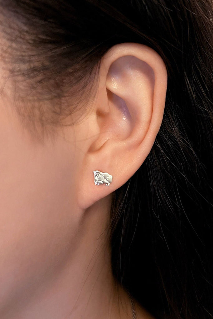 model wearing the sheep stud earrings in the earlobe, showing the dainty size of the earrings