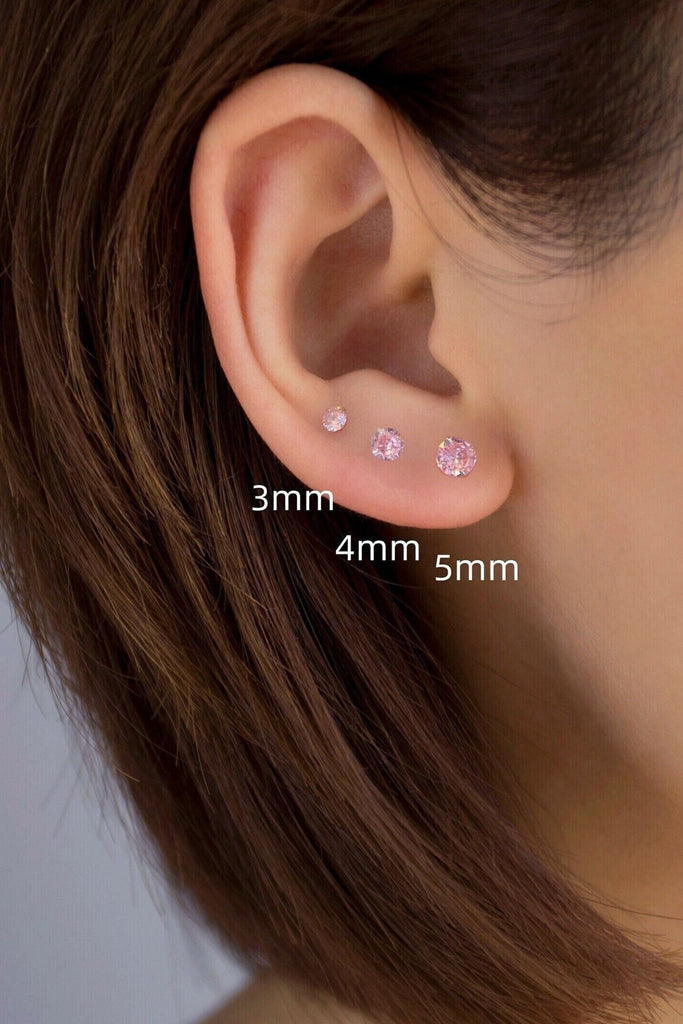 model wearing all three sizes of earrings on the earlobe, showing the size difference between them