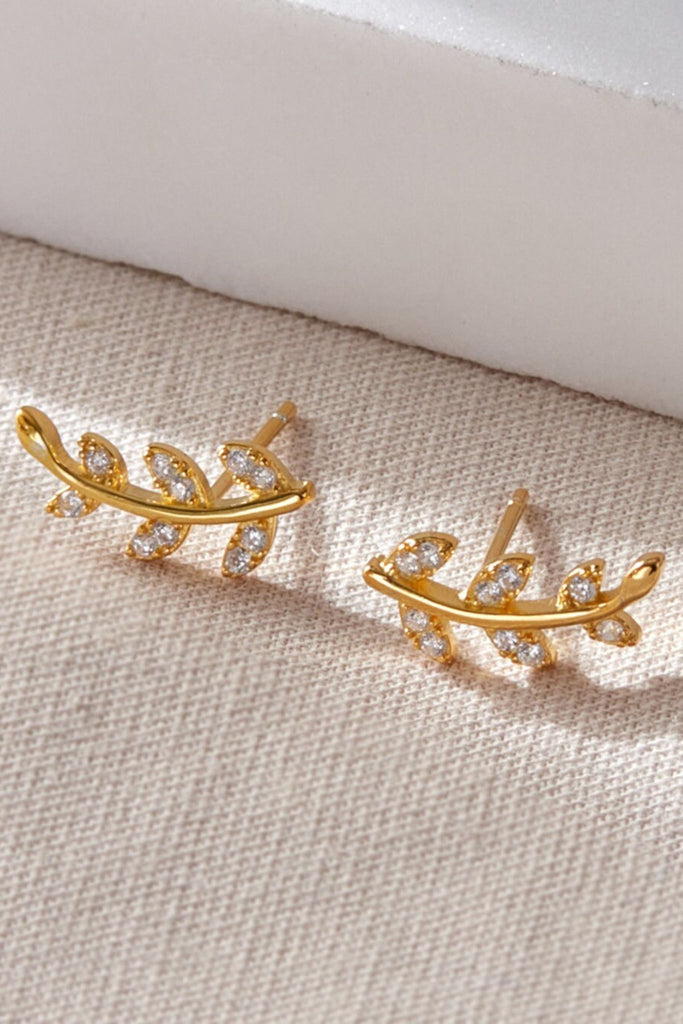 close up of the gold plated silver and white cz leaf stud earrings