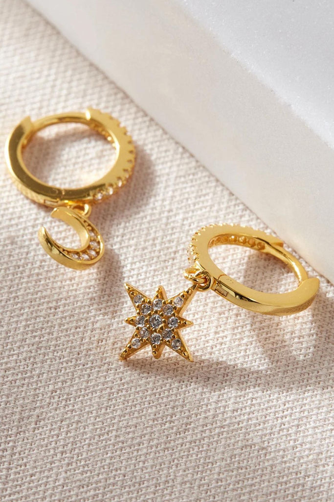 close up of the gold plated silver star and moon asymmetric dangle hoop earrings