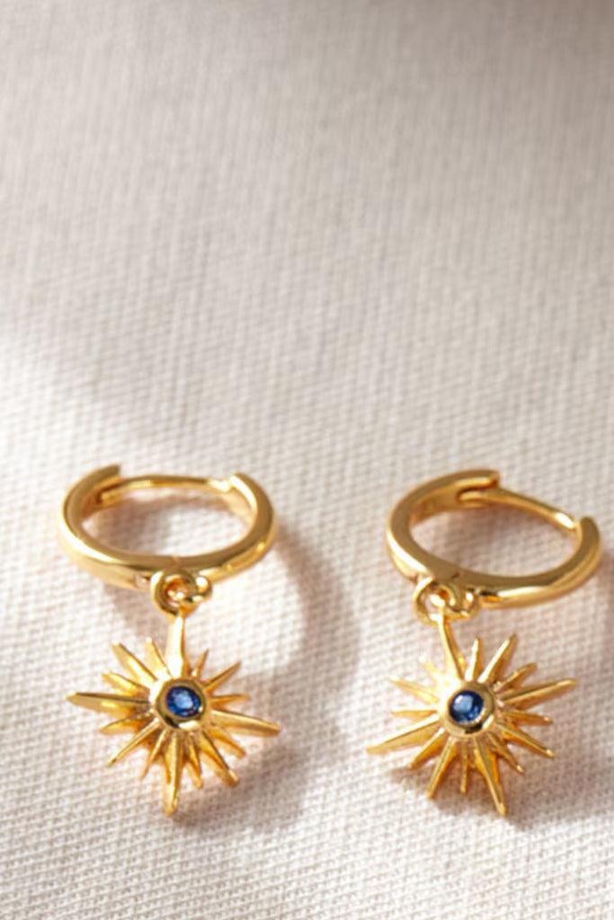close up of the gold and blue cz crystal north star dangle hoop earrings