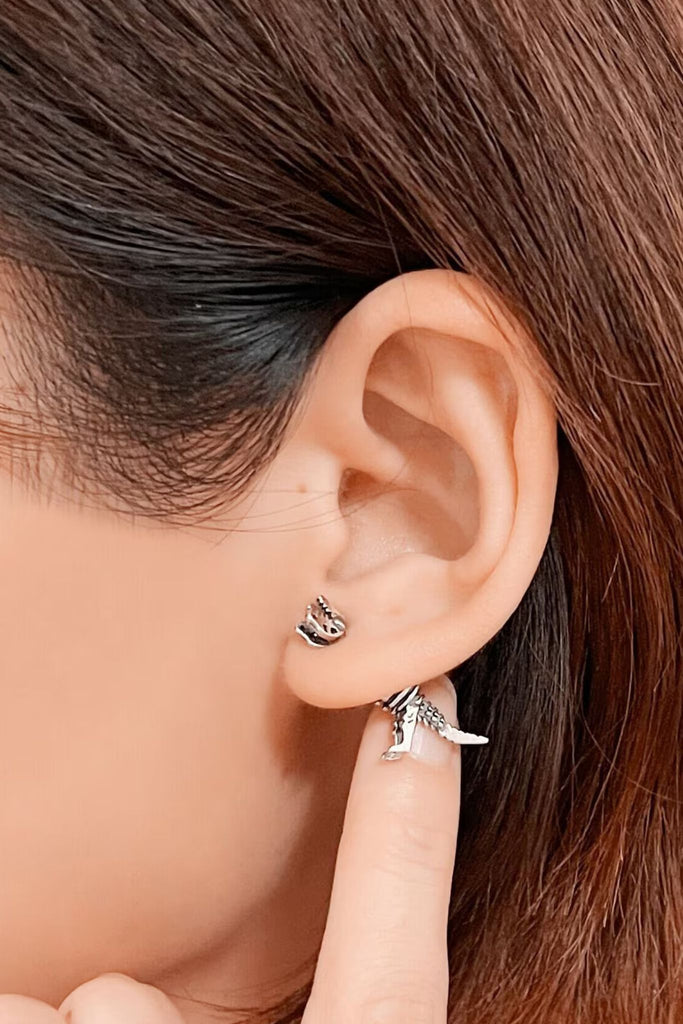 one single ear jacket being worn by a model, showing the front and back of the earring surrounding the earlobe