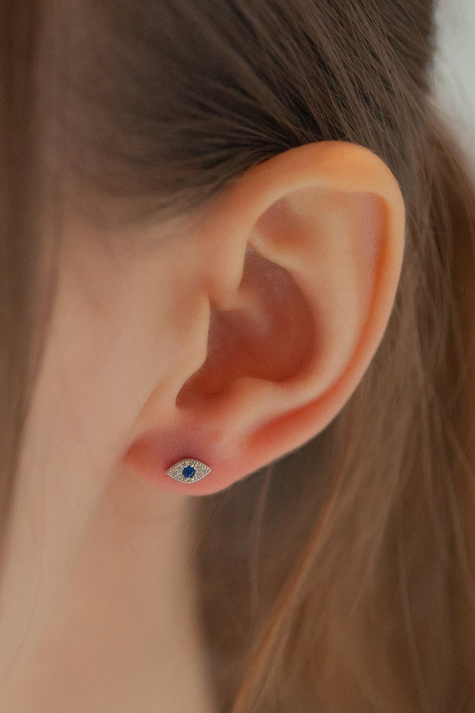 model wearing a sparkly cz evil eye stud earring on the earlobe