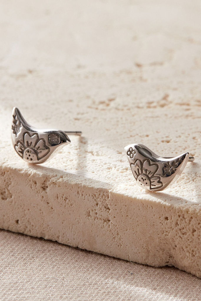 closeup of the silver bird stud earrings
