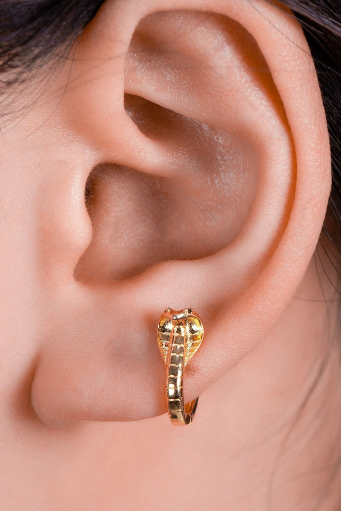 model wearing the gold coloured cobra snake hoop earring on the earlobe