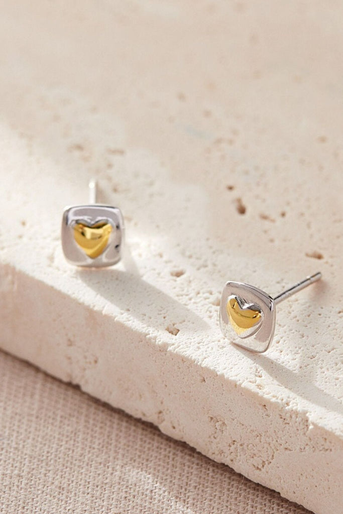 square silver studs with a gold love heart detail