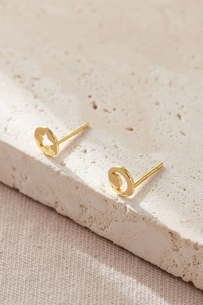 close up of the gold coloured asymmetrical star and moon stud earrings