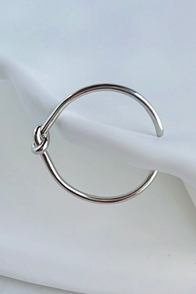 thin open ring made from s925 sterling silver, the ring has a knot design in the middle, symbolising love and unity