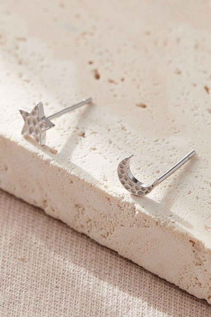 close up of the silver hammered star and moon studs earrings, showing the hammered textured surface of the jewellery