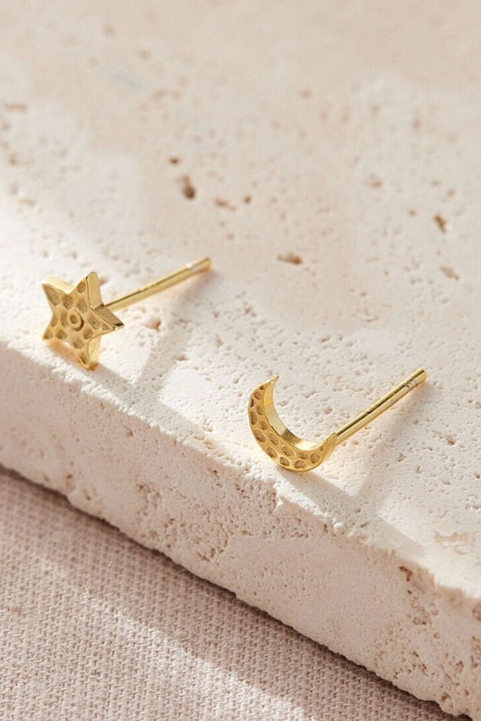close up of the gold plated silver hammered star and moon studs earrings, showing the hammered textured surface of the jewellery