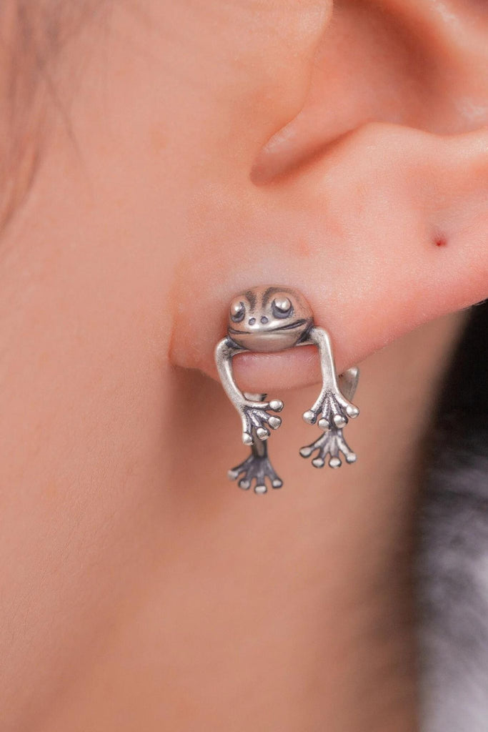 model wearing this silver ear jacket frog earring, showing the size of the jewellery