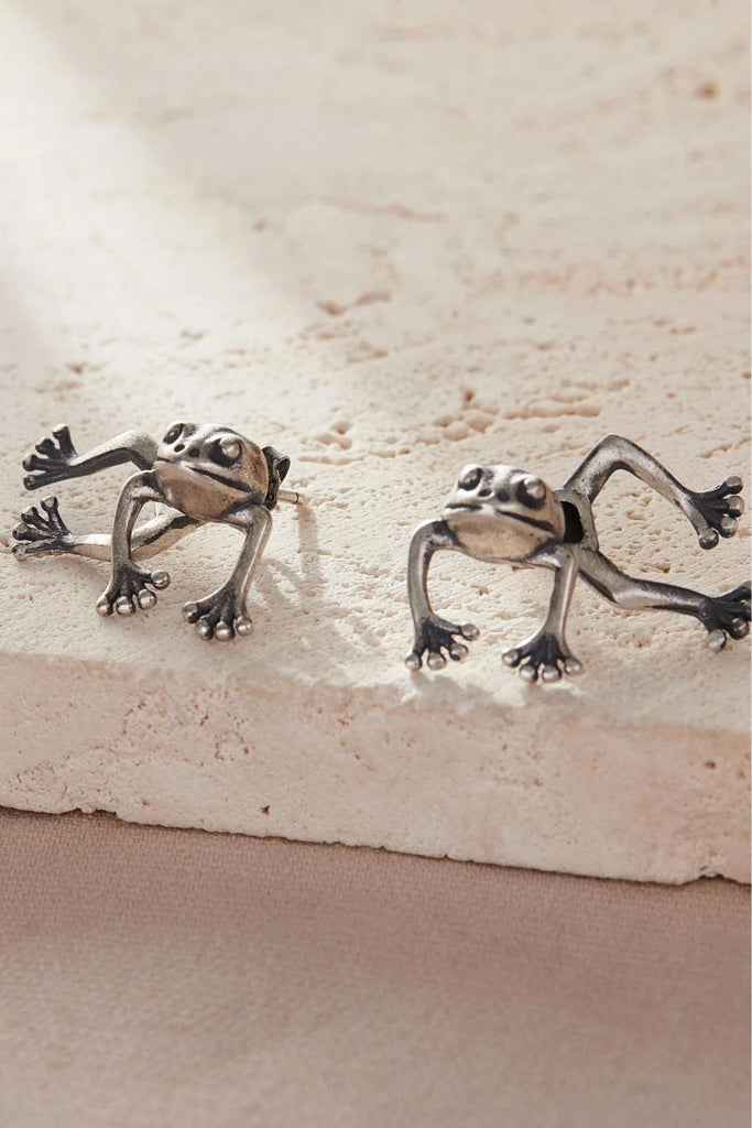 sterling silver frog ear jacket earrings, the earrings separate on each side of the lobe with the frog's head and front legs in front of the ear, the back legs behind the earlobe