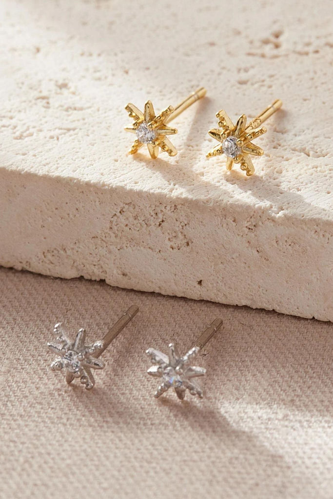 sterling silver starburst earrings with white cubic zirconia crystal in the centre of the earring, the star studs are available in silver and gold 