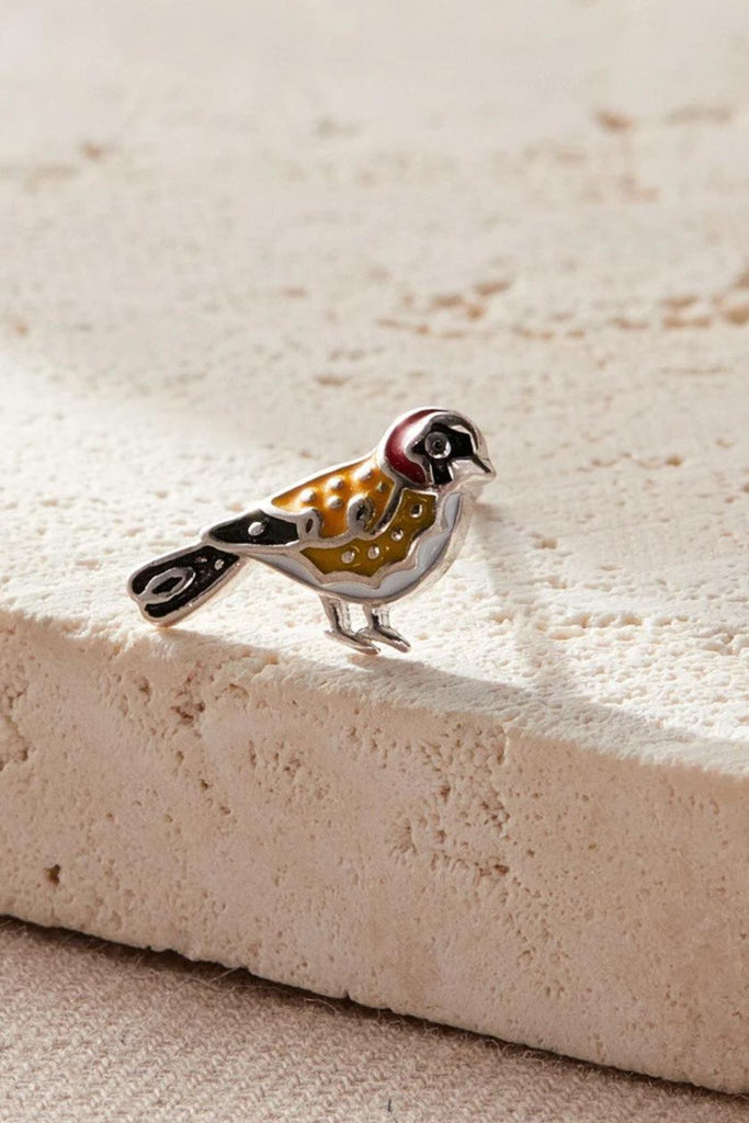 close up of the goldfinch bird stud earring, showing the intricate detail and gold, black and burgundy colouring of the goldfinch.